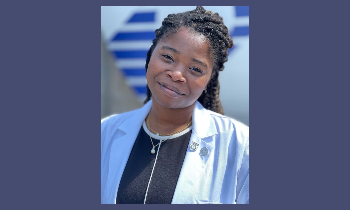 Portrait of Jasmine Brown smiling against a blue background.