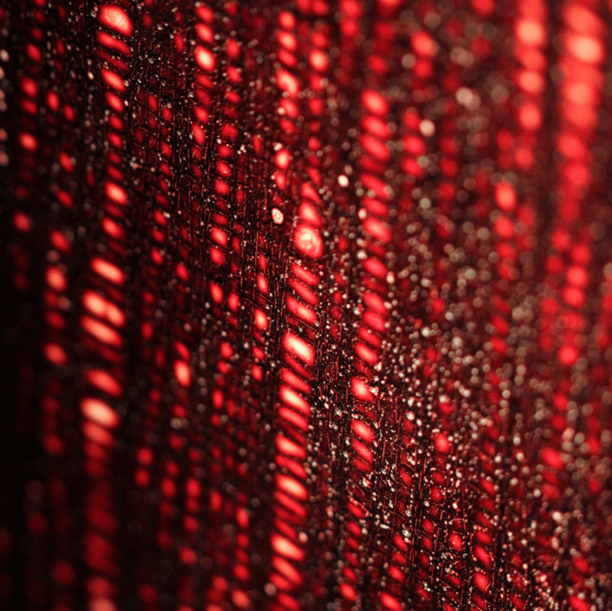 Vibrant shades of red glimmering on thin strips of string