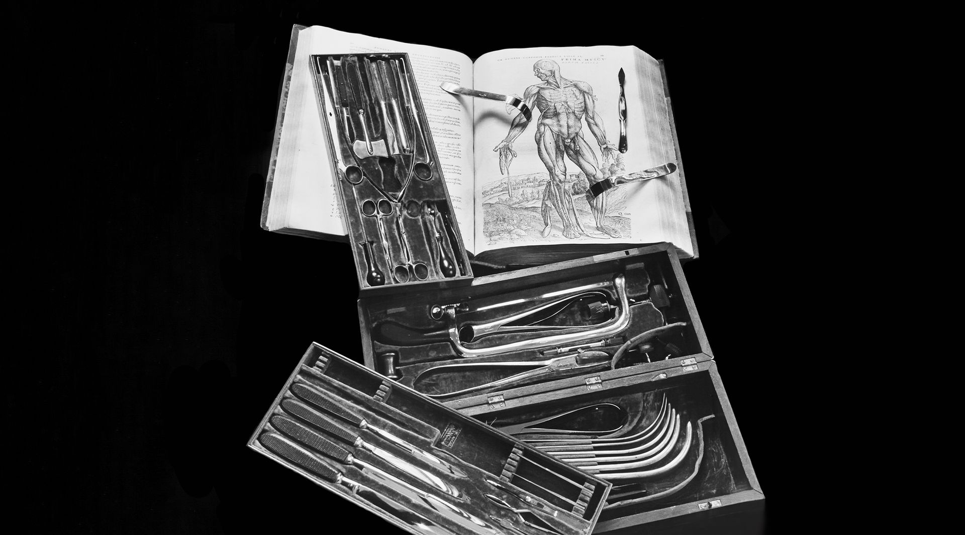 Black and white photo of anatomical book and medical tools