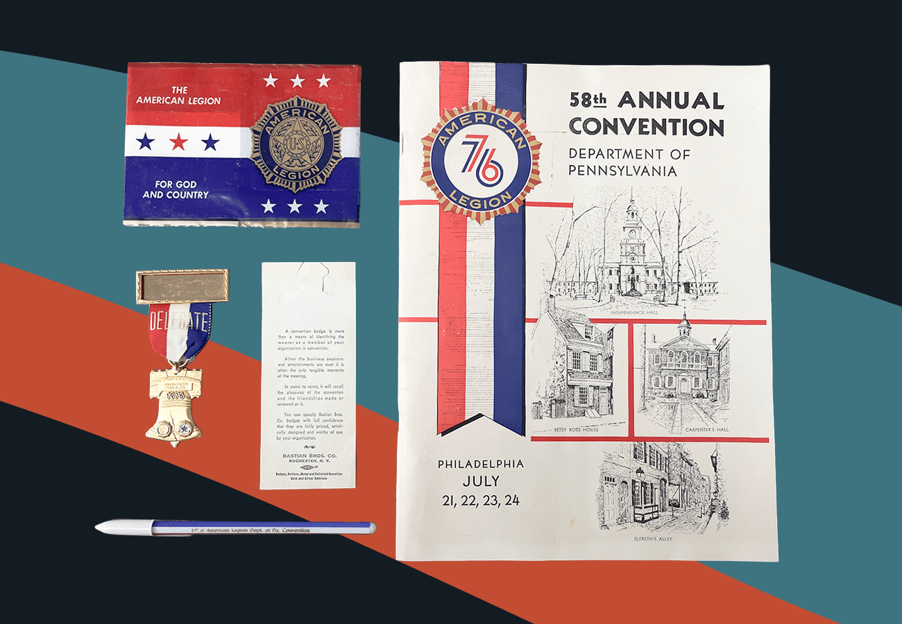 Photo of an assortment of red, white, and blue collateral fro the 58th Annual Convention of the American Legion. Items include a program booklet, pin shaped like the Liberty Bell, and pen. They sit against a dark blue background with a muted red and blue swoosh running through the middle.