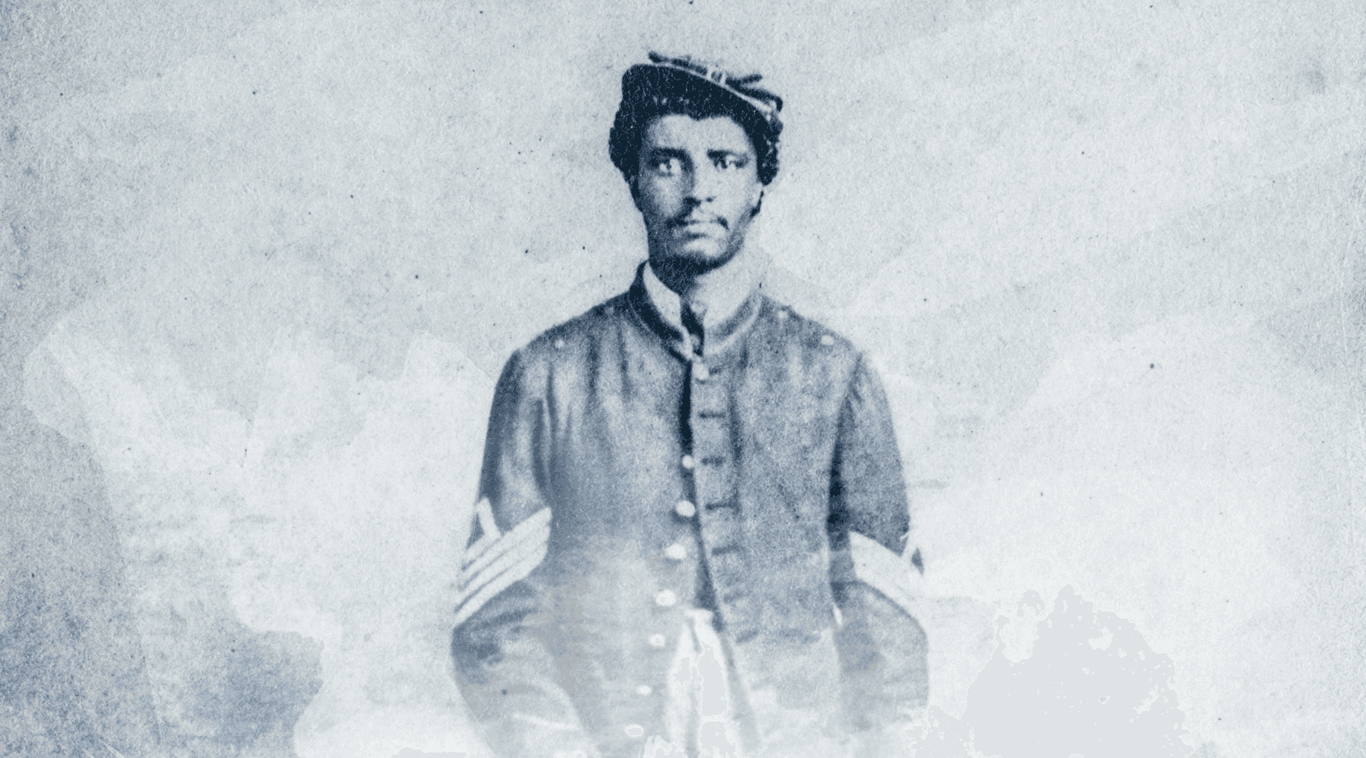 Blue, faded photograph of soldier in Civil War-era uniform and hat