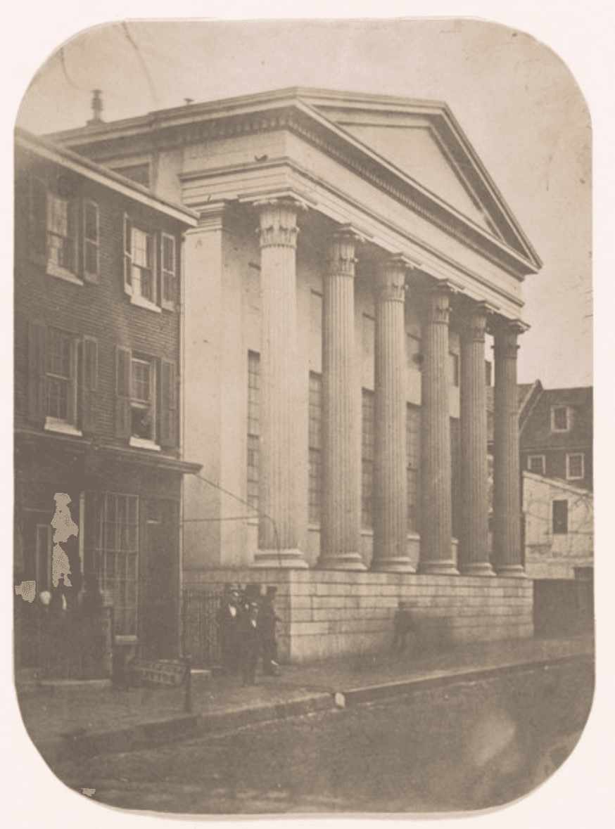 Street view of a white marble building with Greek columns